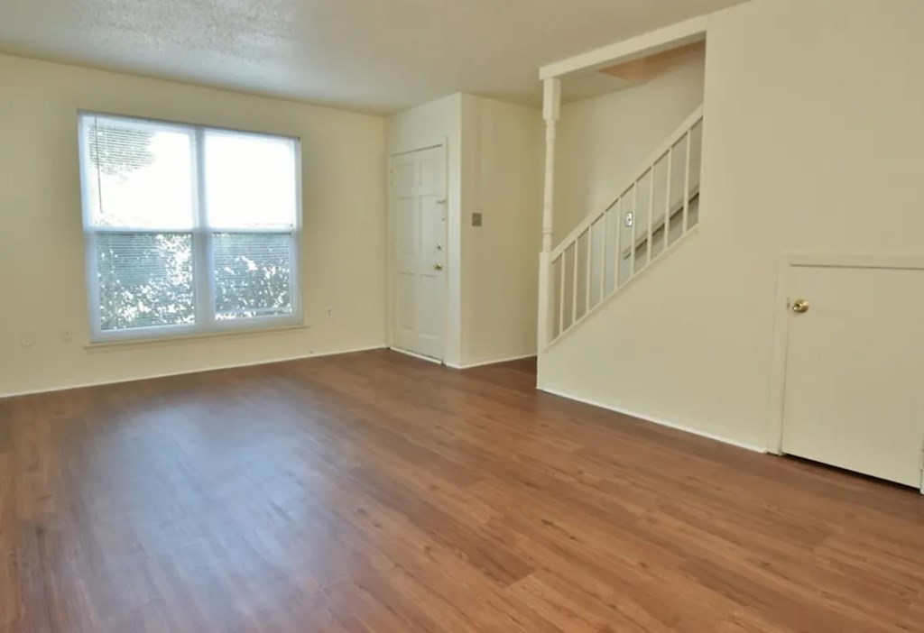 A room with wooden floors and a staircase.